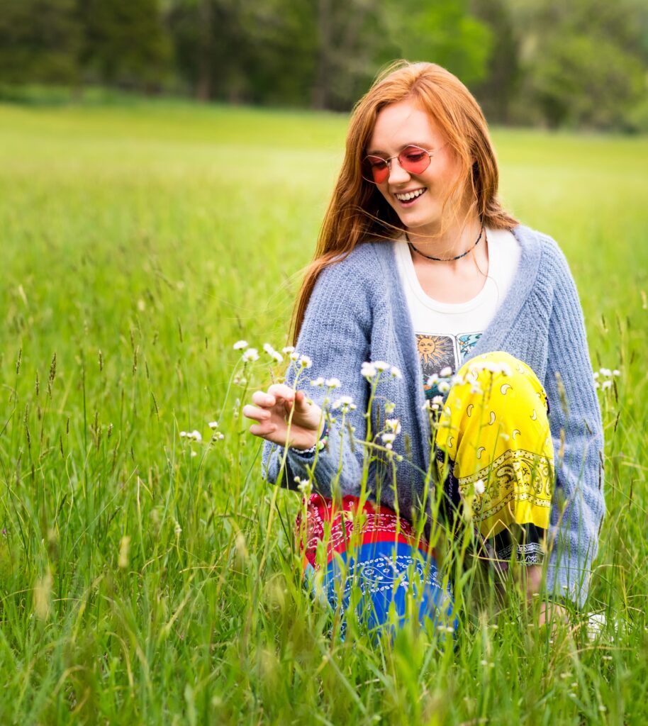 Elle Kay sitting in a field of flowers